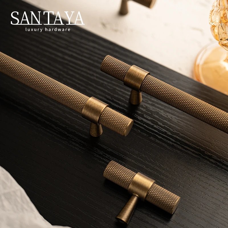 Brushed brass cabinet handles resting on a black ribbed panel