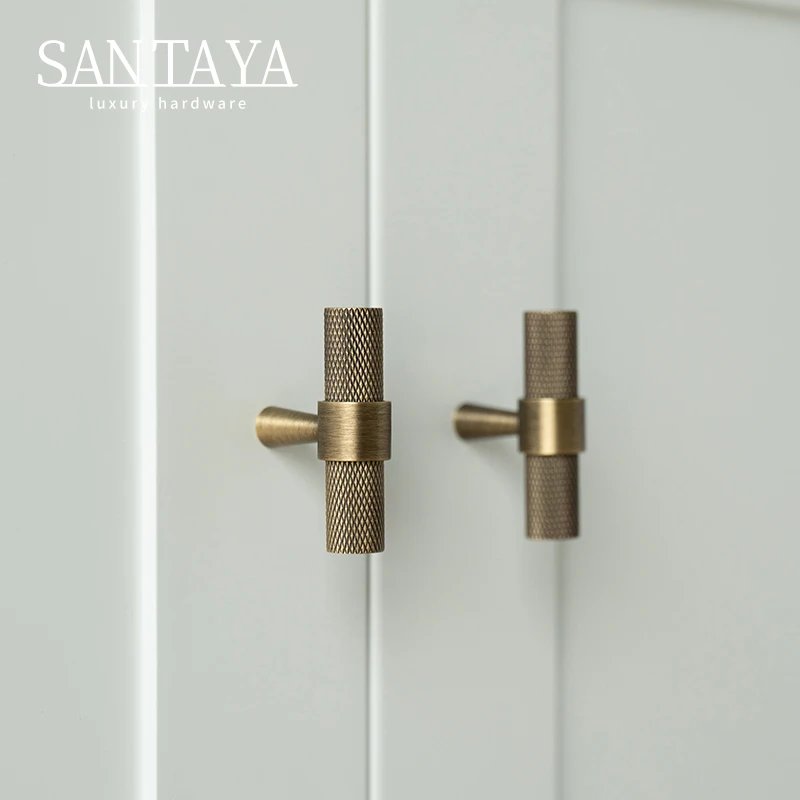 Small brass T bar knobs fitted to white cabinet doors
