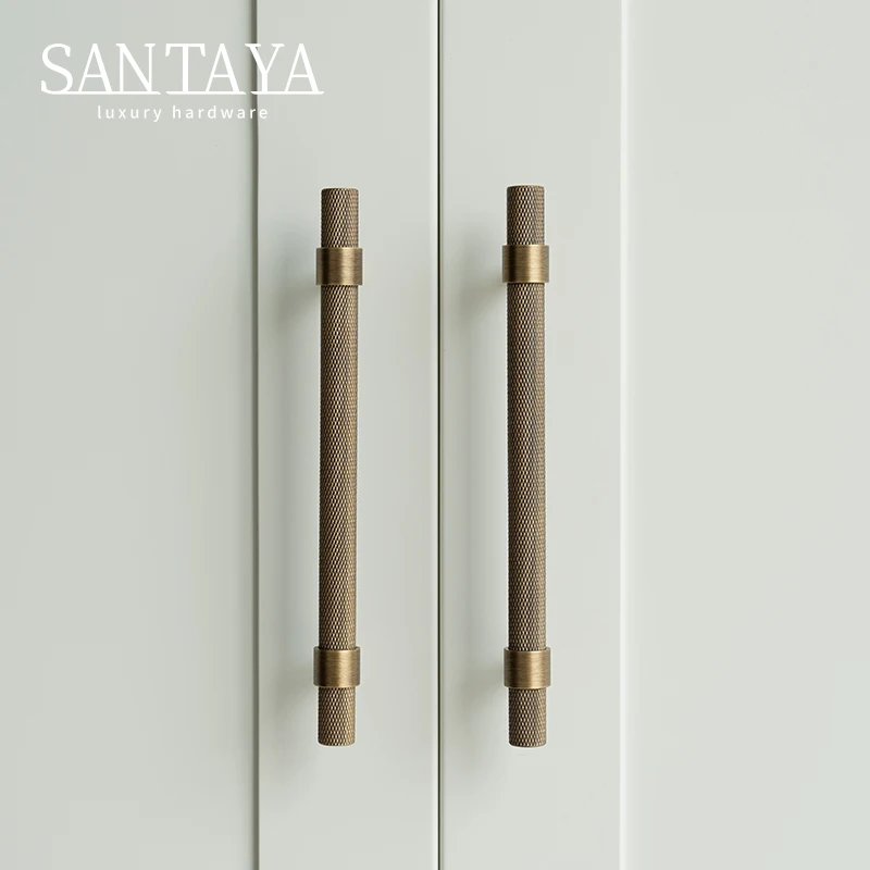 Pair of antique brushed brass handles on white cupboard doors