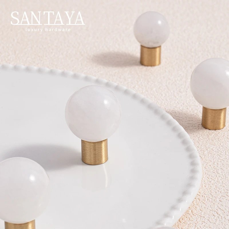 White round cabinet knobs arranged beside a strand of pearls