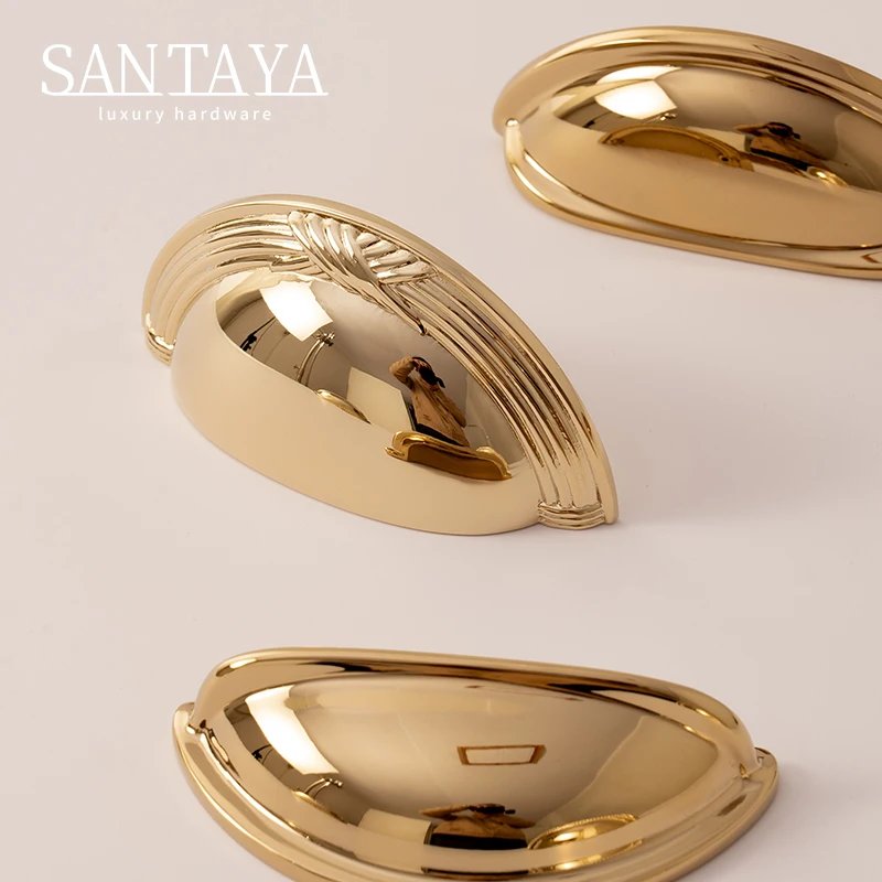 Close view of curved solid brass shell drawer handles