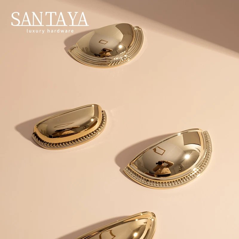 Gold shell cup handles arranged in a diagonal on a beige surface